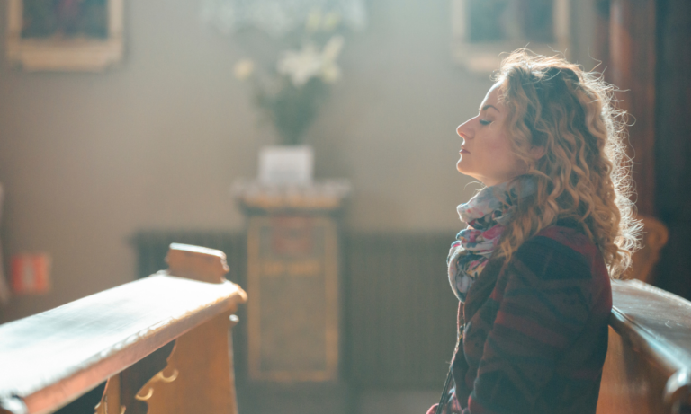 Woman sitting on a church pew looking concerned, reflecting on church misunderstandings about marriage.